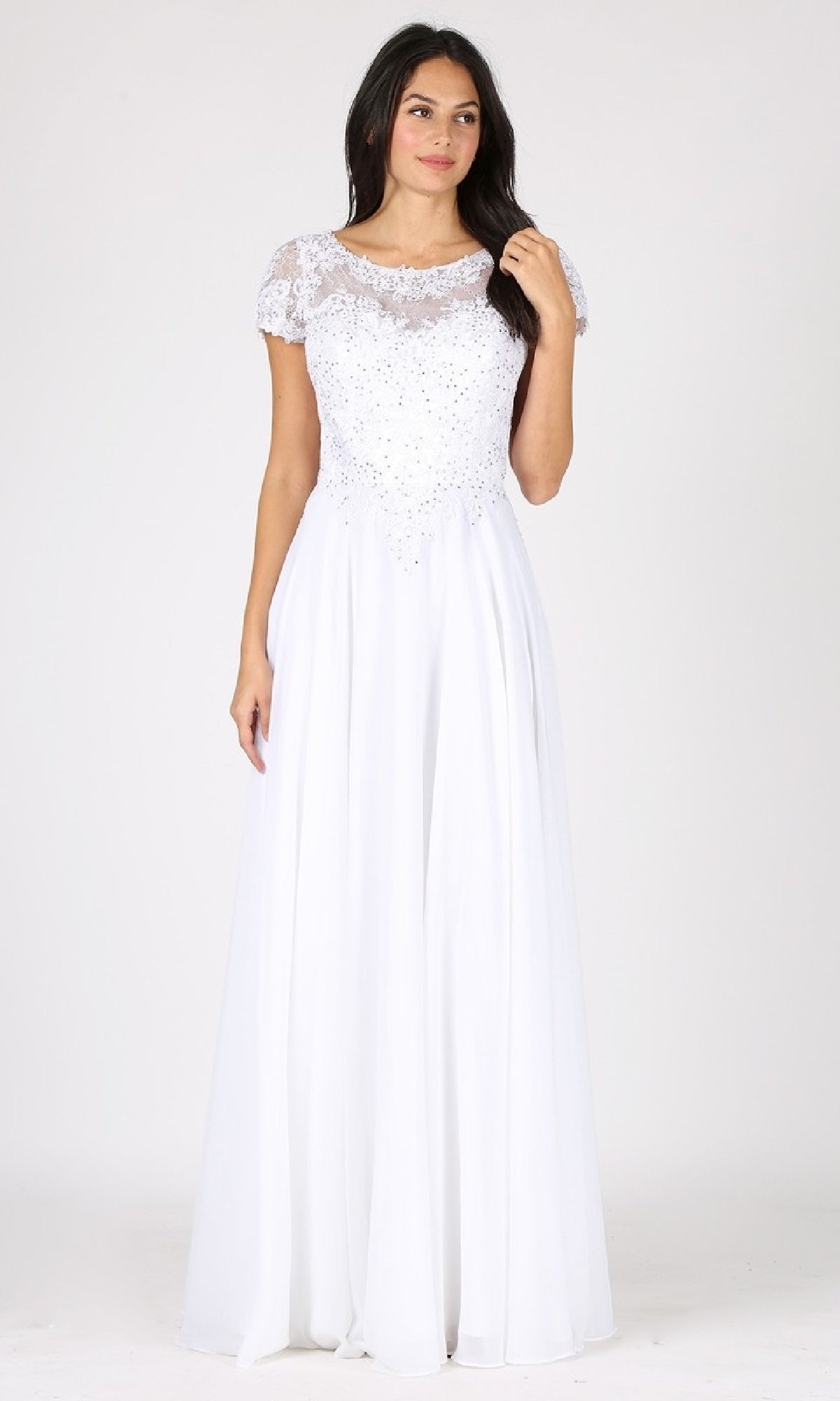 A woman wears the Eureka 4909, a short-sleeve long A-line formal dress with an embellished lace bodice and a flowing floor-length chiffon skirt.